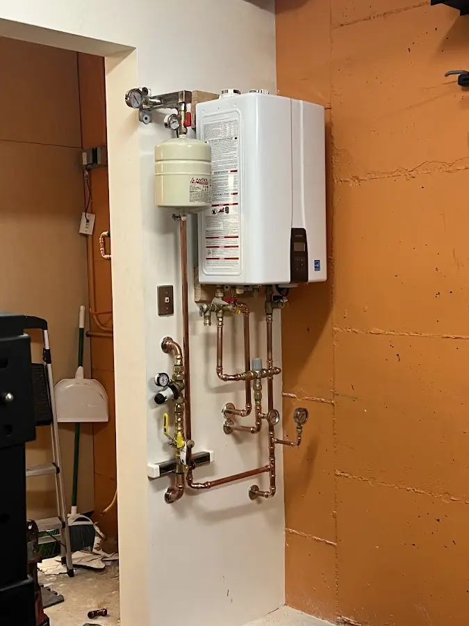 Plumbing technician inspecting water heater connections in King City